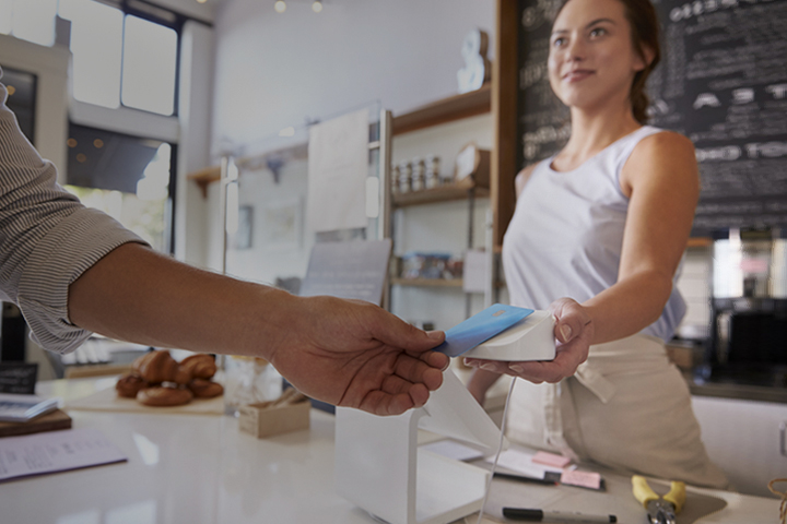 Customer making contactless card payment at a coffee shop