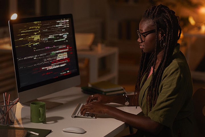 Computer engineer writing code on desktop computer