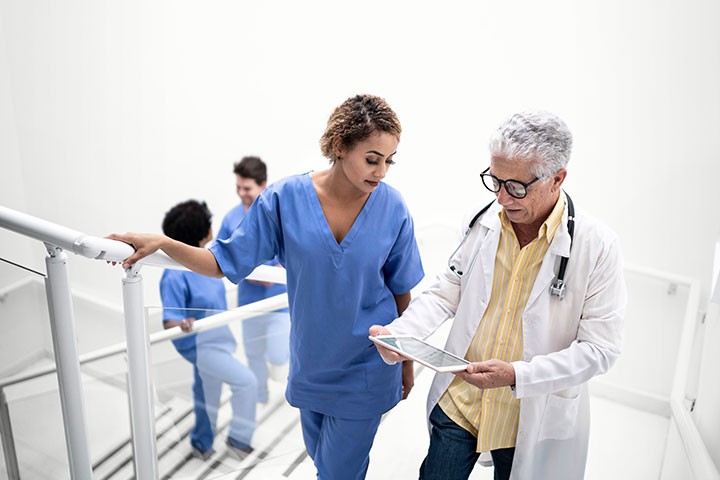 Doctor and nurse using tablet walking up steps