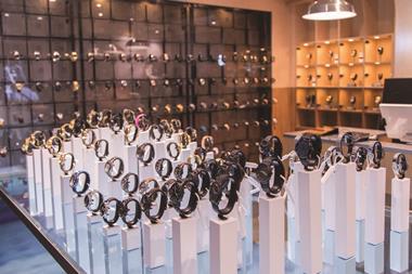 72 watches are displayed on plinths, parts of which sit below the surface of an under-lit tank