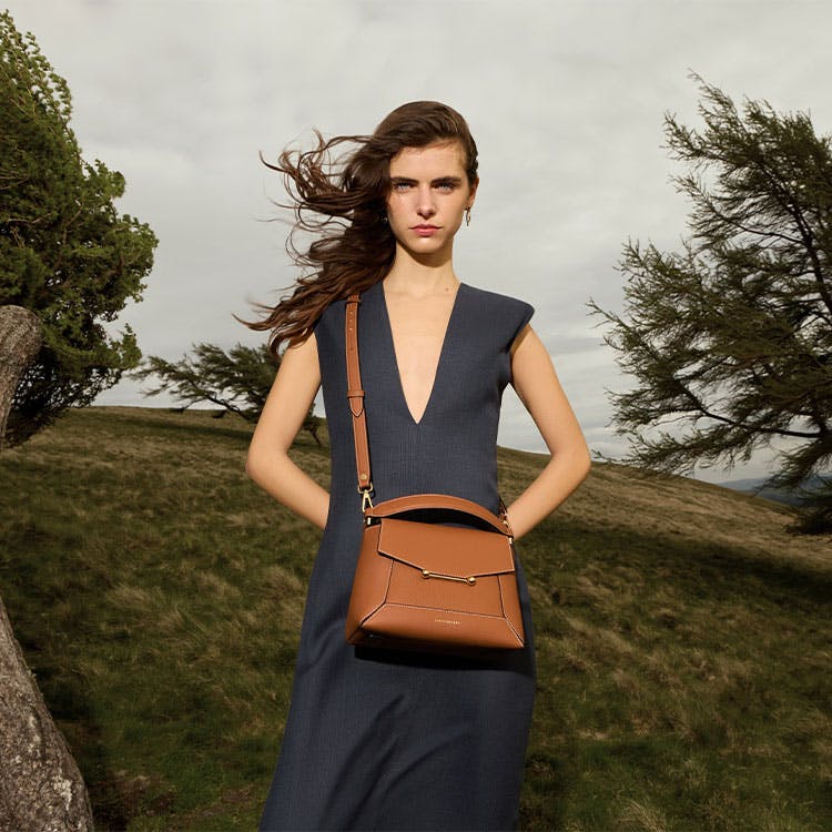 A woman in a dress holding a brown purse