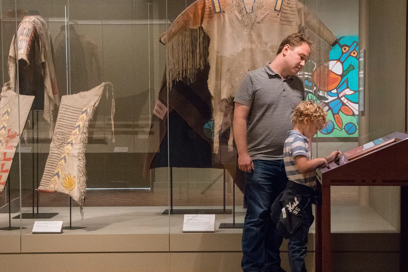 A man and a child read an interpretive plaque in the African Art galleries at the Detroit Institute of Arts.