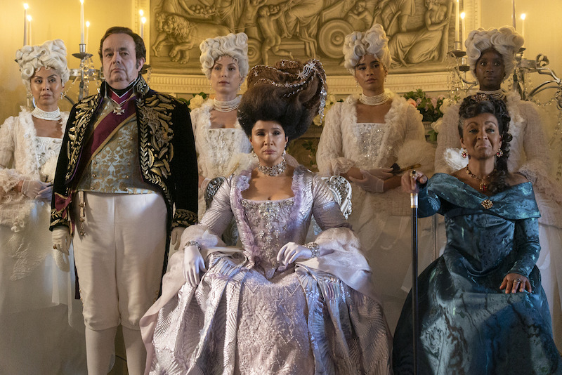  Hugh Sachs as Brimsley, Golda Rosheuvel as Queen Charlotte, and Adjoa Andoh as Lady Agatha Danbury gather together in grand ballgowns in season 3 of 'Bridgerton'