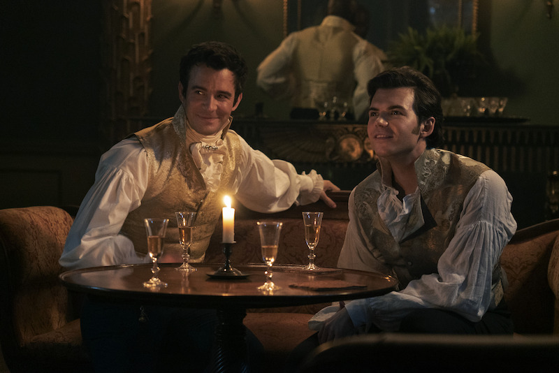 Luke Thompson as Benedict Bridgerton and Luke Newton as Colin Bridgerton sit together having drinks in season 3 of 'Bridgerton'