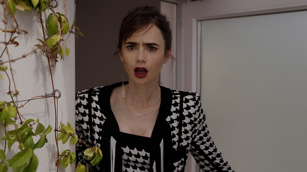 Lily Collins as Emily opens a door with a shocked expression in Season 3 of 'Emily in Paris'