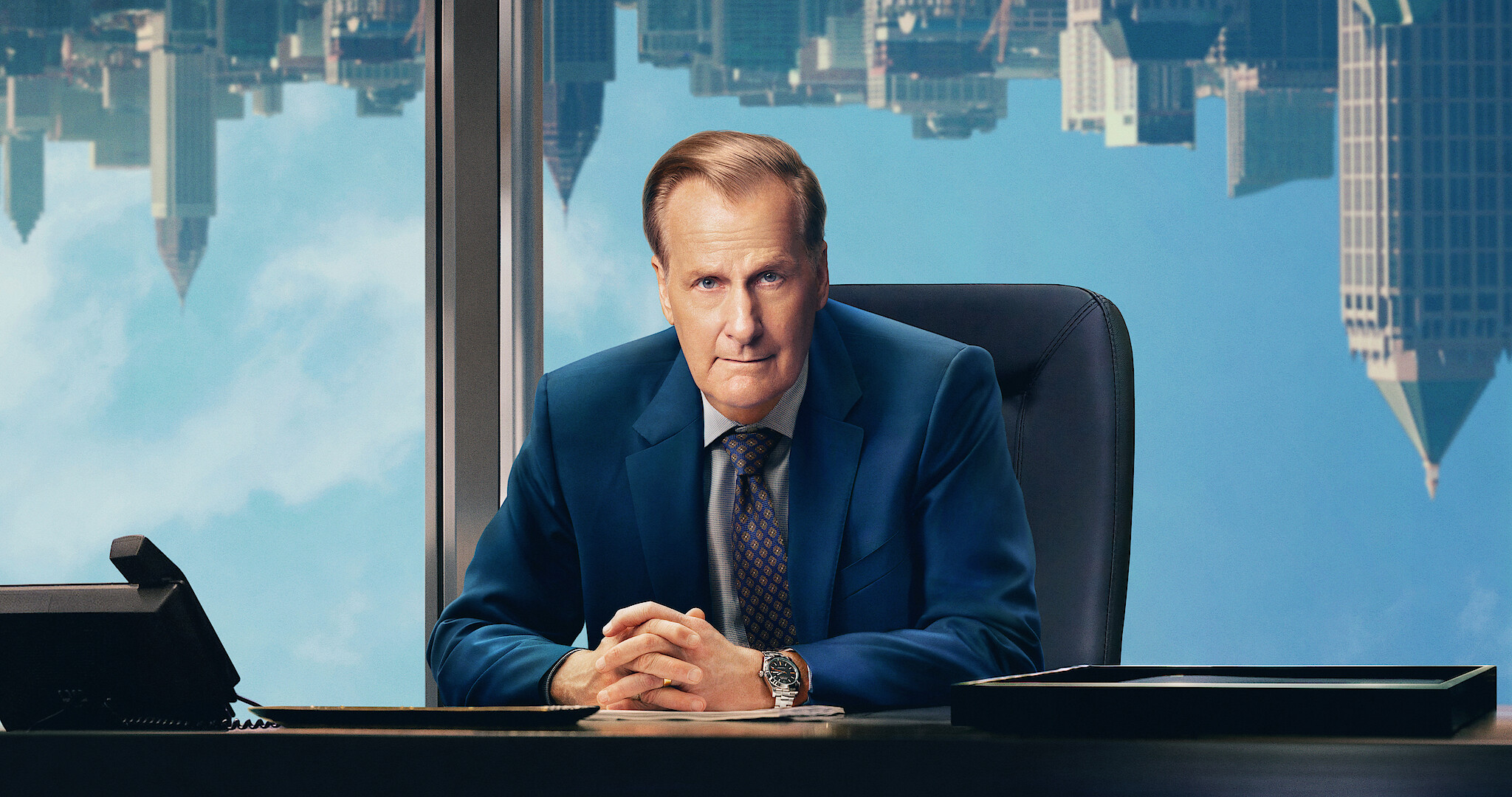 A Man in Full - Jeff Daniels sitting behind a desk with an upside down skyline behind him. 