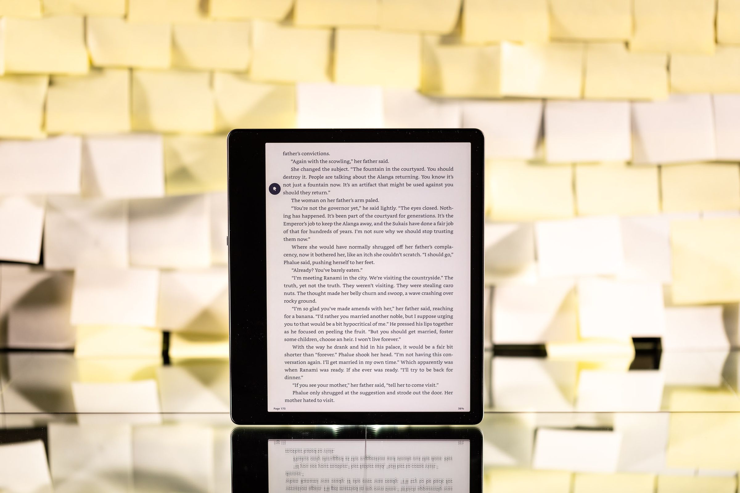 The Kindle Scribe positioned upright against a background of yellow post-it notes.