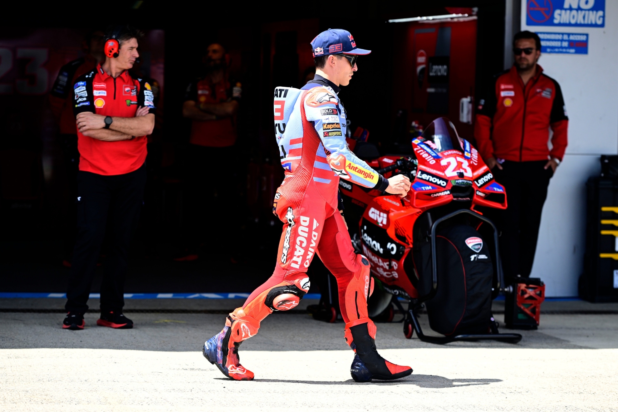 Marc M�rquez pasa delante de la moto de Bastianini y del box del Ducati oficial.