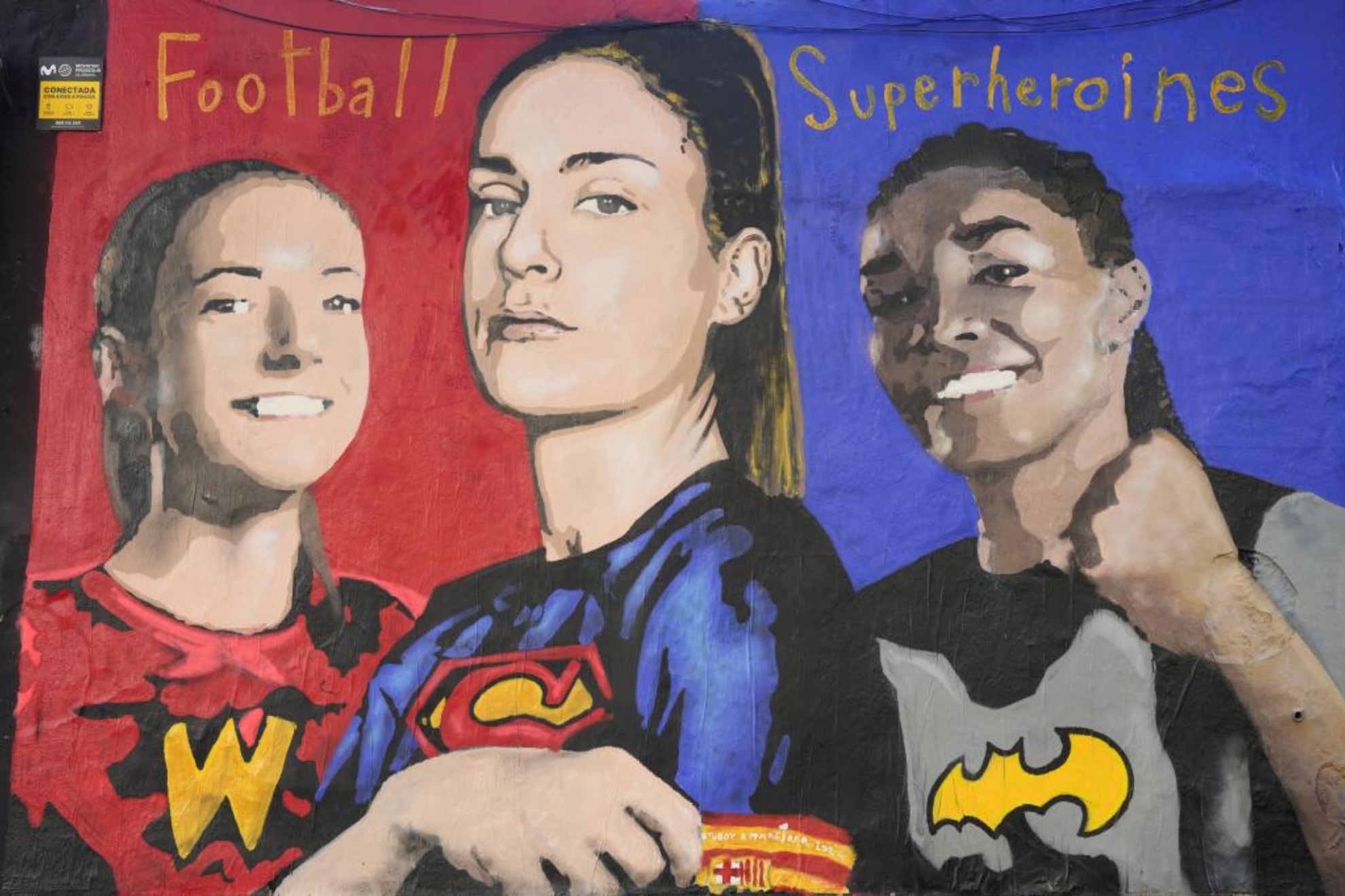 El mural con Aitana con el traje de Wonderwoman, Alexia el de Superwoman y Salma el de Batgirl.