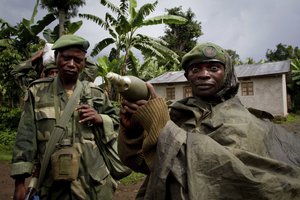 A Congolese government army soldier displays a mortar round after his unit returned from fighting against rebel forces, Congo