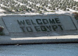 Suez Canal – The amphibious assault ship USS Saipan (LHA 2) pass a “Welcome to Egypt” sign