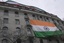 People show an Indian flag from the roof of the Indian High Commission as protestors of the Khalistan movement demonstrate on the streets in London