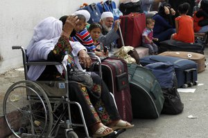 Palestinian families wait outside the terminal at the Rafah border crossing in the southern Gaza Strip on September 28, 2013