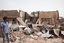 A man walks by a house hit in recent fighting in Khartoum, Sudan, Tuesday, April 25, 2023. Sudan's warring generals have pledged to observe a new three-day truce that was brokered by the United States and Saudi Arabia to try to pull Africa's third-largest nation from the abyss.