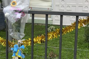 Flowers lay at the building gate where four children between nine months and 10 years old and their mother were found killed, Tuesday, Dec.26, 2023 in Meaux, east of Paris.