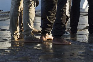 Rescued migrants line up after disembarking from the Italian Coast Guard ship 'Fiorillo' in the harbor of of Lampedusa, Southern Italy, Wednesday, April 22, 2015.