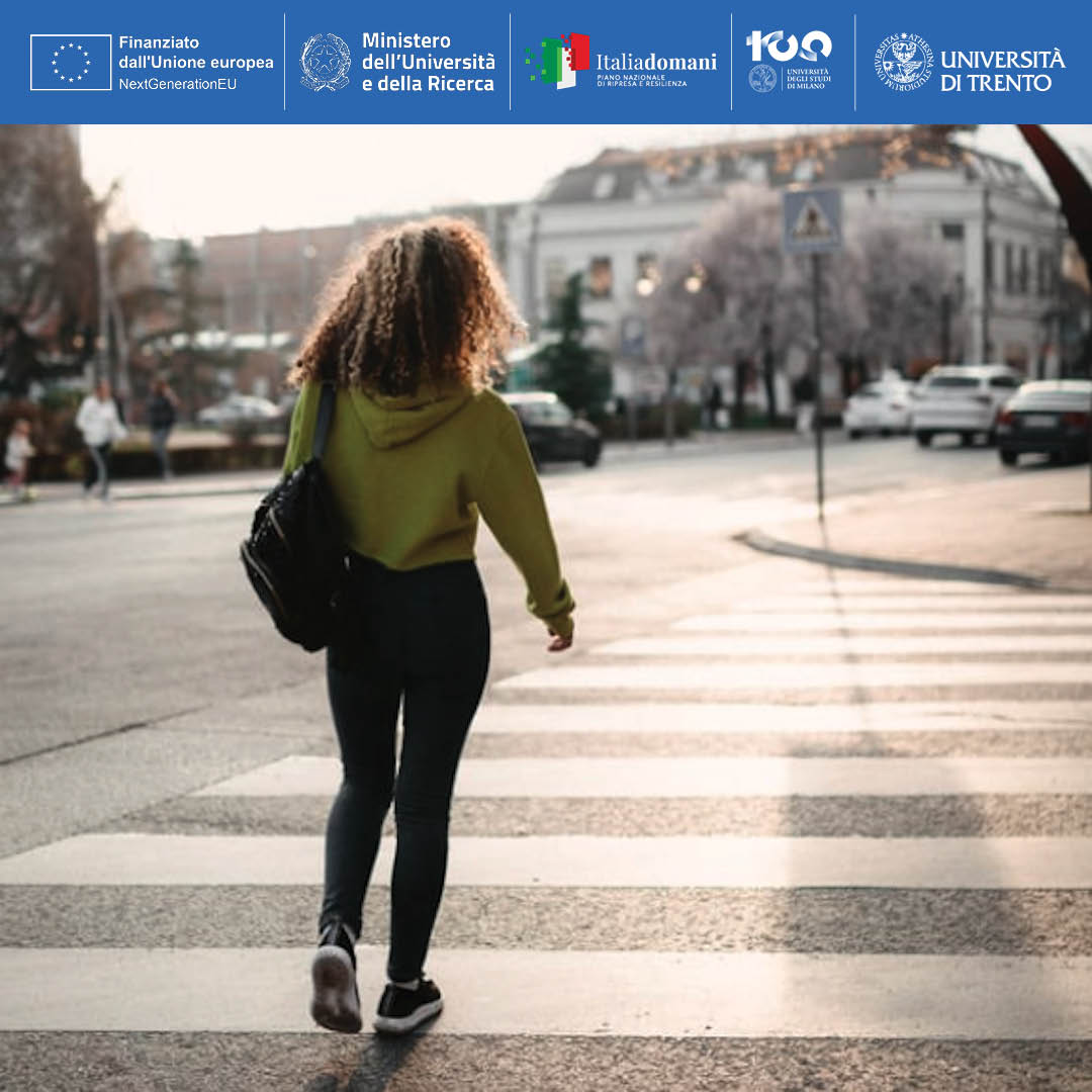 Persona di spalle attraversa la strada sulle strisce pedonali