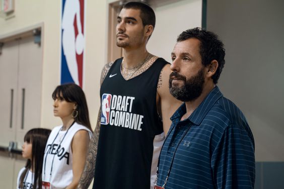 HUSTLE. (L-R) Ainhoa Pillet as Lucia, Maria Botto as Paola, Juancho Hernangomez as Bo Cruz and Adam Sandler as Stanley Sugerman in Hustle. Cr. Scott Yamano/Netflix © 2022.