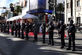 Police keep watch near protestors gathered outside the 96th Academy Awards