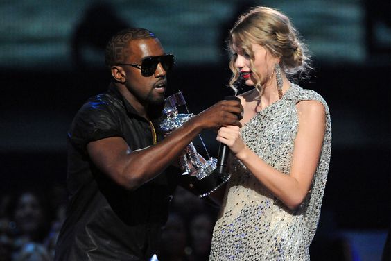 Kanye West (L) jumps onstage after Taylor Swift (C) won the "Best Female Video" award during the 2009 MTV Video Music Awards at Radio City Music Hall on September 13, 2009 in New York City. 