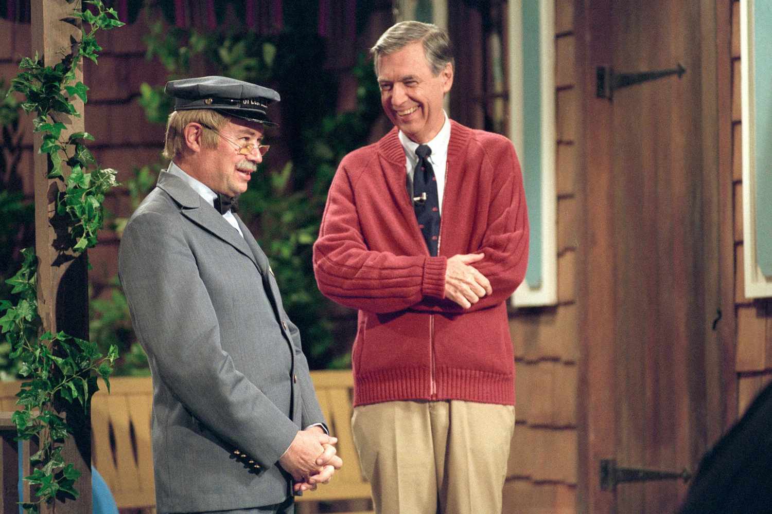 Fred Rogers and David Newell in costume on porch set of Mister R