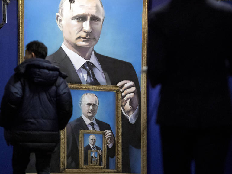 Visitantes observam quadros com retratos de Putin em exposição em museu de Moscou
