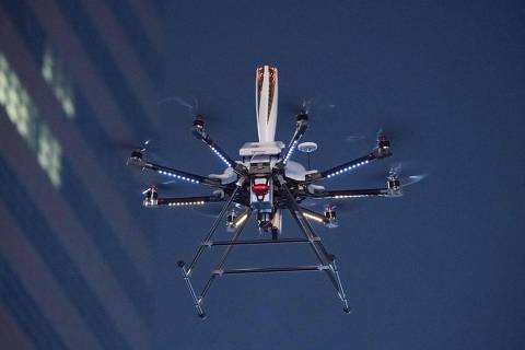 A torch-bearing drone carrying the Olympic flame makes its way through a Gwanghwamun square in central Seoul on January 13, 2018.
Cheering crowds welcomed the Olympic flame to a freezing Seoul, where the torch will be paraded for four days before making its way to Pyeongchang for the start of the Winter Games. / AFP PHOTO / STR