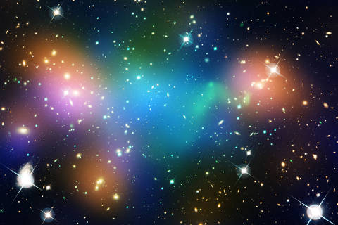 Imagem mostra o aglomerado Abell 520 formado pelo choque entre dois aglomerados de galáxias. A distribuição de matéria escura (em azul) está deslocada com relação às estrelas das galáxias (em laranja) e do gás quente (em verde) evidenciando ser de constituição diferente da matéria que conhecemos. (crédito: NASA, ESA, CFHT, CXO)