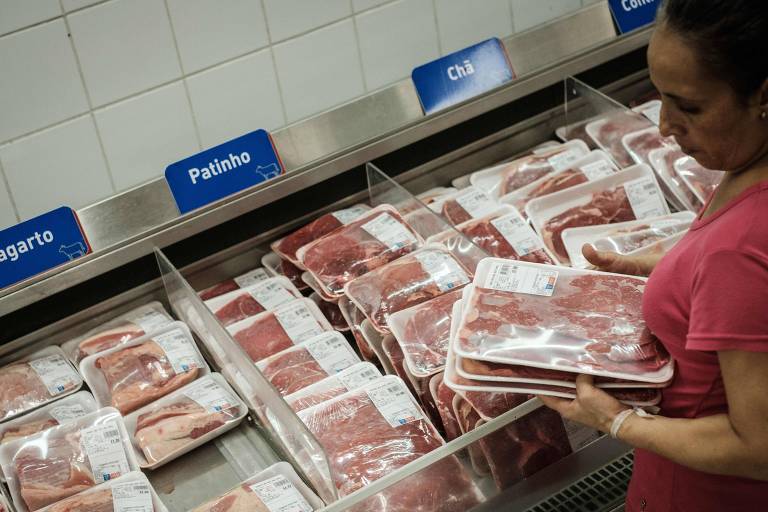 Mulher escolhe pedaço de carne em supermercado no Rio