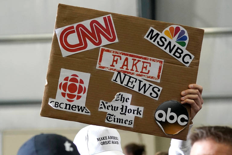 Cartaz mostra nomes de veículos de comunicação e, no centro, as palavras 'fake news' durante discurso em Washington do presidente dos EUA, Donald Trump