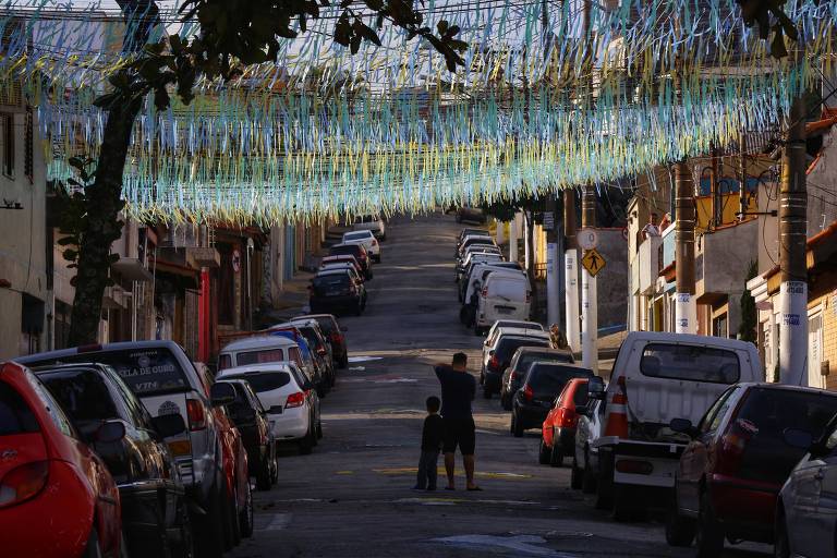 Moradores fotografam rua na zona leste de São Paulo decorada para a Copa do Mundo