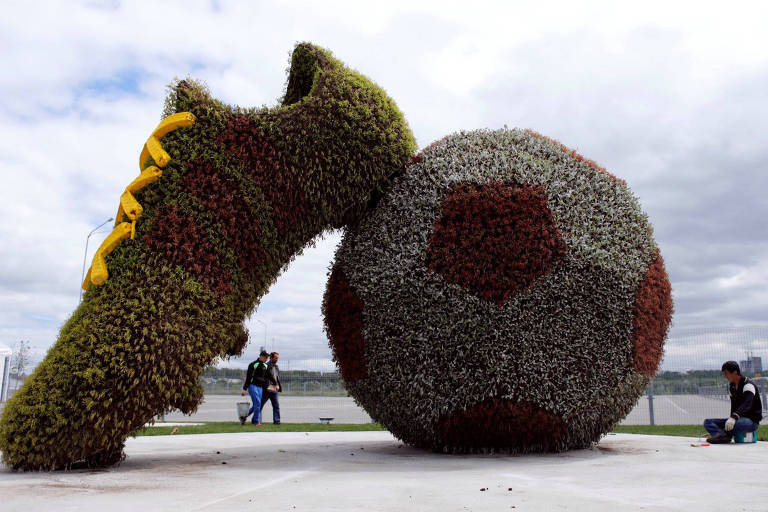 Trabalhadores dão os retoques finais em uma decoração fora do Kazan Arena no início da Copa do Mundo da Rússia 2018, Rússia