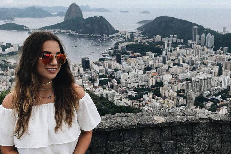 A estudante Camilla Pimenta, nascida na Austrália, em viagem ao Rio de Janeiro. Ela está em um ponto alto. Ao fundo, o pão de açúcar, prédios e a baía de guanabara