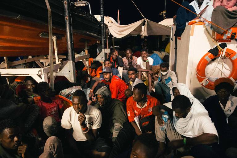 Cerca de 30 homens se apertam entre a casa de máquinas e botes salva-vidas do navio Lifeline