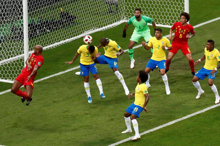 Jogadores dos dois times em campo perto de uma goleira