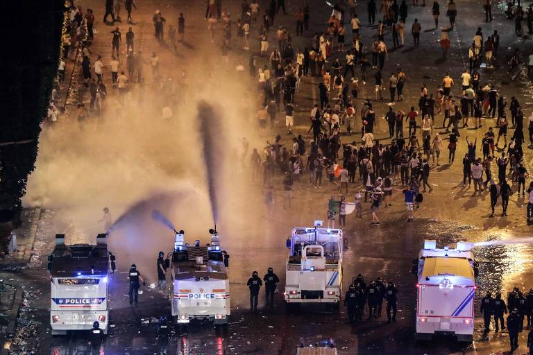 Polícia usa jatos de água para dispersar multidão durante distúrbios na Champs-Elysees, em Paris, durante comemorações da vitória no Mundial