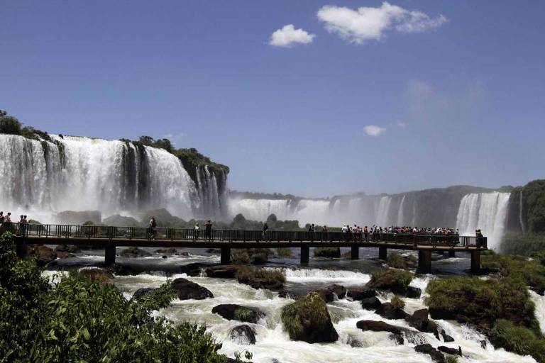 Pessoas em plataforma sobre cachoeira 