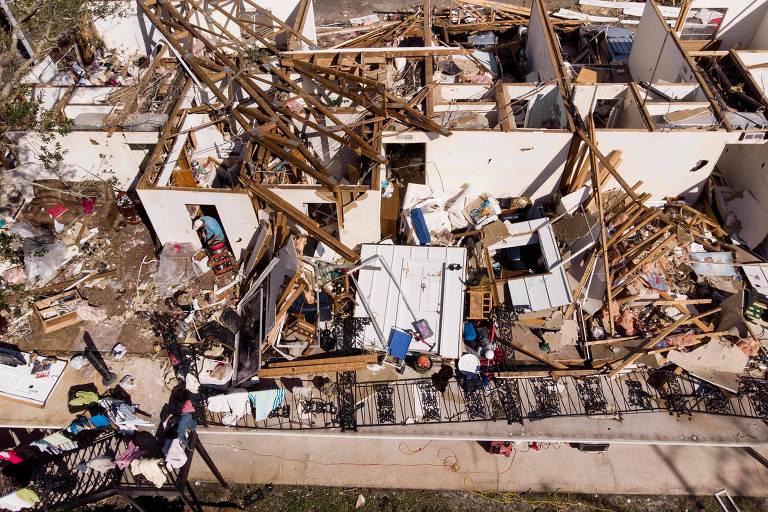 Homem faz buscas nos escombros de um prédio destruído após a passagem do furacão Michael em Panamá City, na Flórida