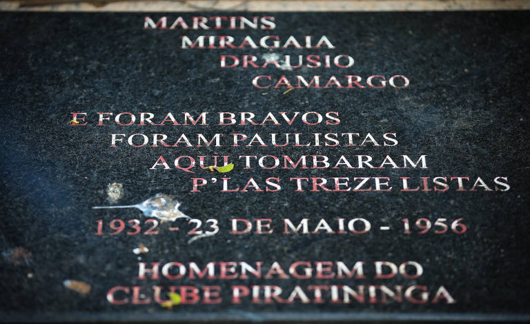 Placa com os dizeres "Martins, Miragaia, Drausio e Camargo. Foram bravos, foram paulistas, aqui tombaram pelas treze listas; 1932 - 23 de maio - 1956; homenagem do clube Piratininga"