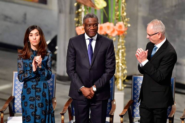 A ativista iraquiana Nadia Murad com o ginecologista congolês Denis Mukwege (centro) e o membro do comitê do Nobel Henrik Syse durante a cerimônia de entrega do prêmio em Oslo 