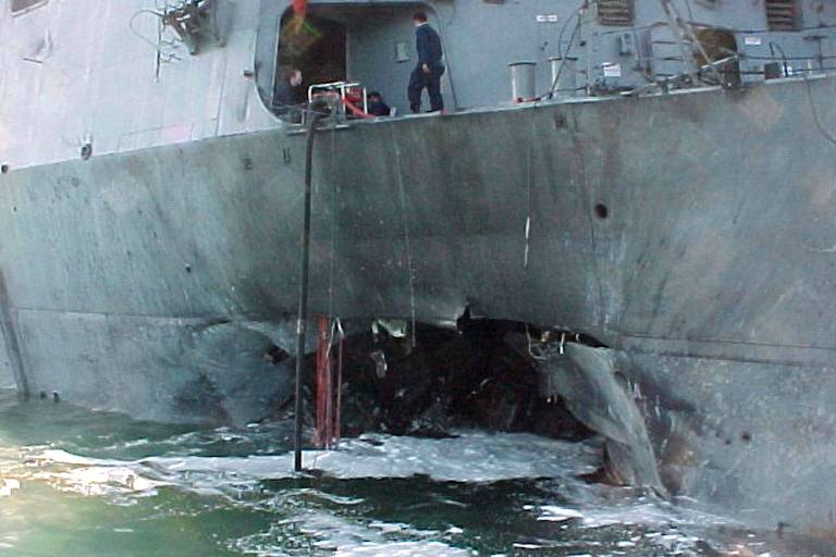 Foto mostra o casco do destróier americano USS Cole após ataque a bomba durante parada para reabastecimento da embarcação no porto de Aden, Iêmen, , em 12 de outubro de 2000.  