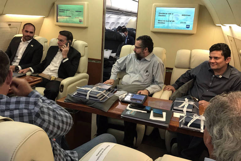 Jair Bolsonaro e ministros durante viagem a Davos com kits da FAB sobre a mesa