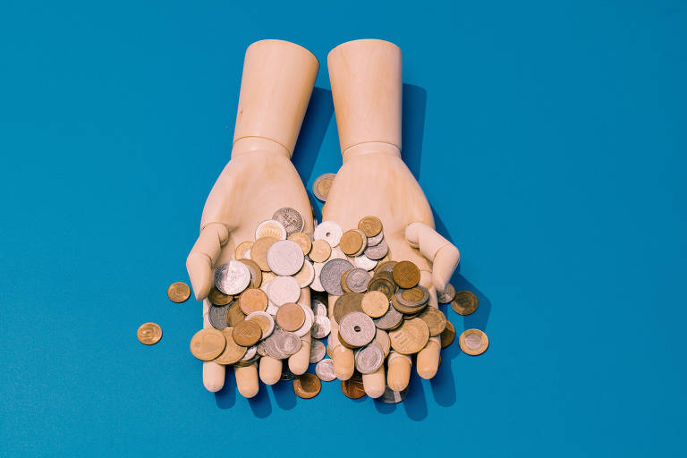 Mãos de manequins de madeira segurando um punhado de moedas