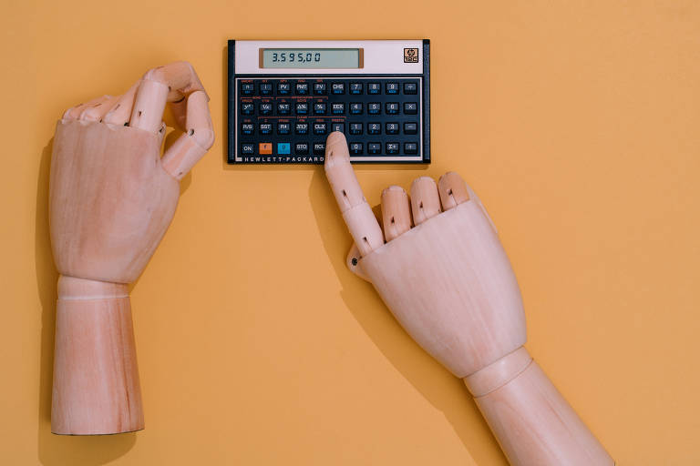 Mãos de manequim mexendo em calculadora científica, sobre mesa laranja 