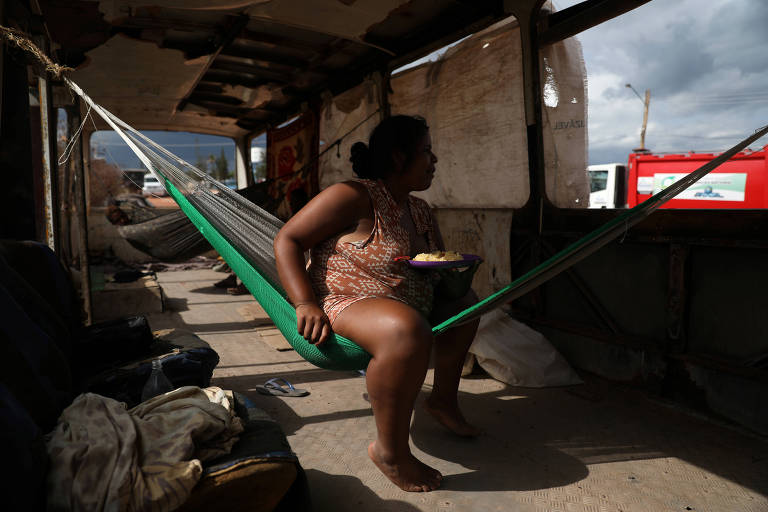 Venezuelanos vivem em ônibus abandonado