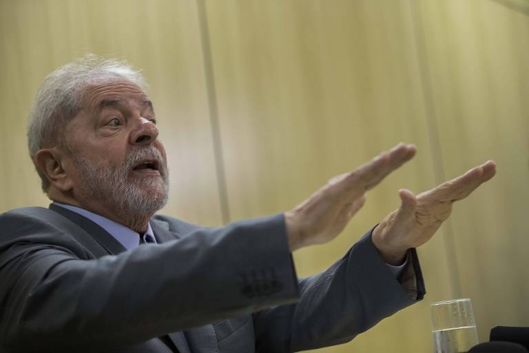 O ex-presidente Lula, com os braços para frente, em entrevista na Policia Federal em Curitiba, onde está preso