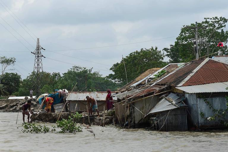 Moradores observam neste sábado (4) casas destruídas em Khulna, Bangladesh, após passagem do ciclone Fnai pelo país