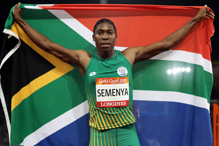 A atleta sul-africana Caster Semenya estende por trás de si bandeira do país de origem comemorando a vitória na final dos 800 metros nos Jogos da Comunidade Britânica.