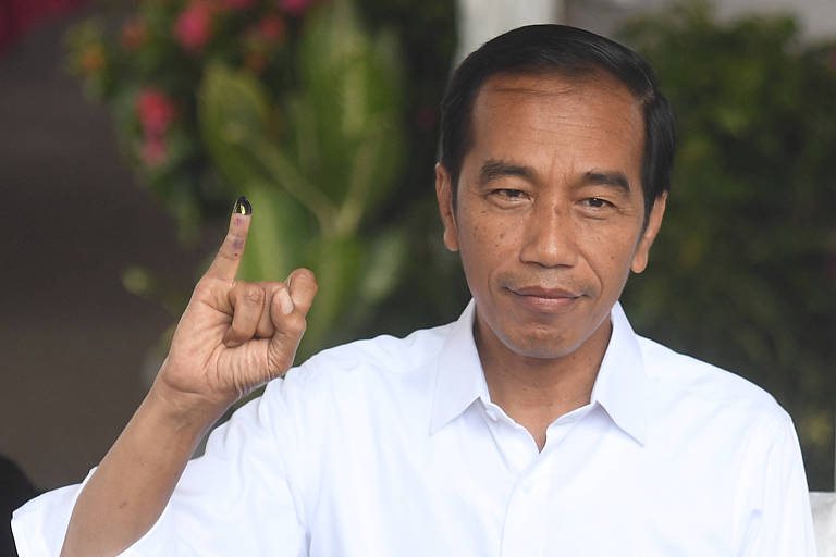 Joko Widodo mostra dedo sujo de tinta que comprova que o presidente já votou na eleição 