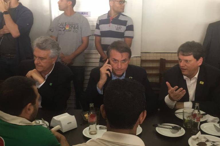 O presidente Jair Bolsonaro (PSL) durante almoço com caminhoneiros em Anápolis (GO), ao lado do governador de Goiás, Ronaldo Caiado (DEM) e do ministro Tarcísio de Freitas (Infraestrutura)